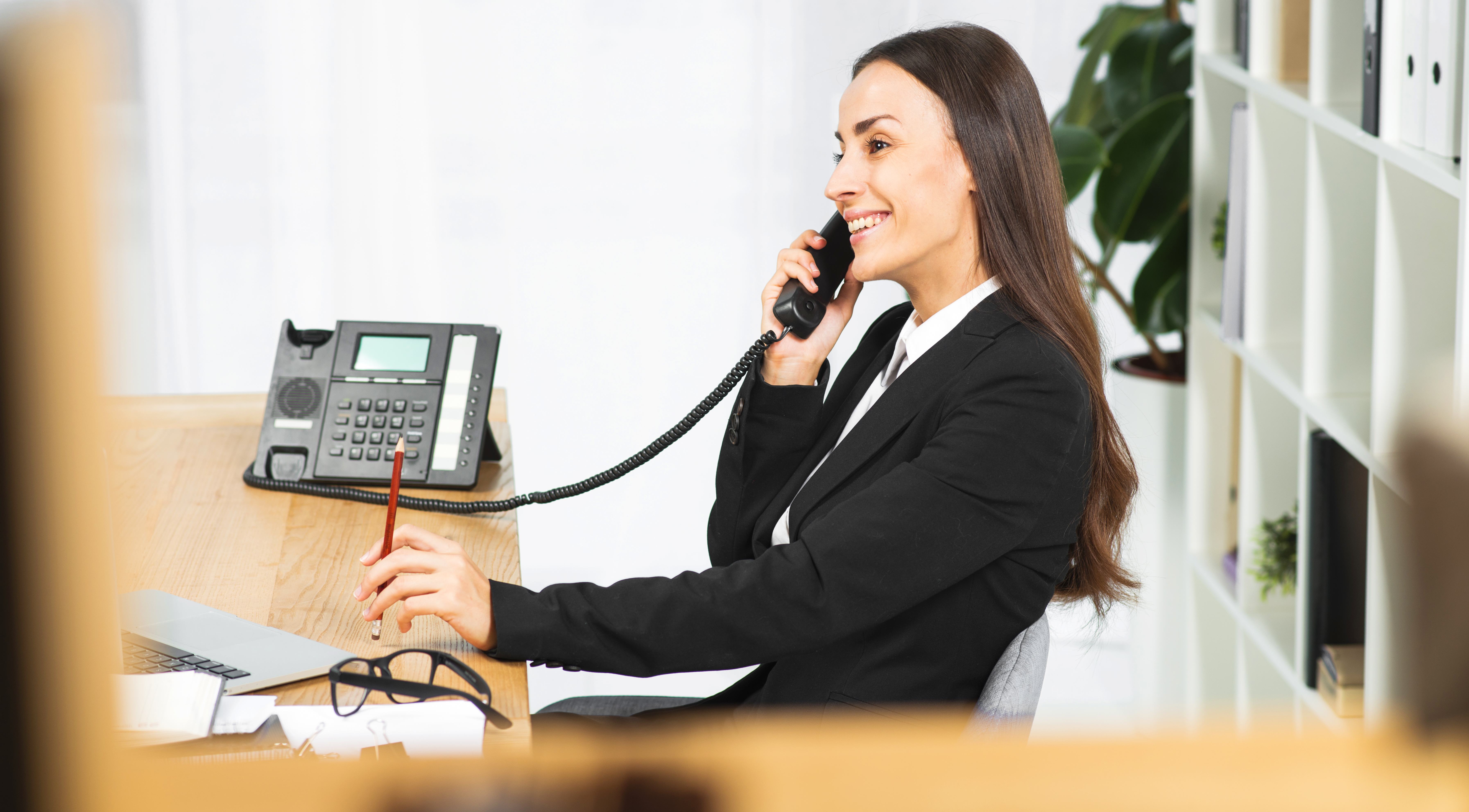 Atendente profissional atendendo telefone em escritório moderno